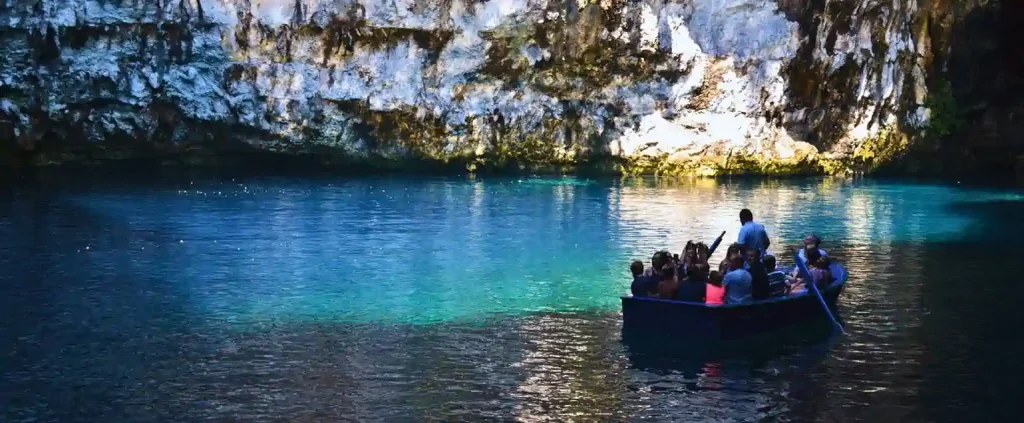 Small group on a boat tour inside a turquoise cave lake in the Ionian Islands