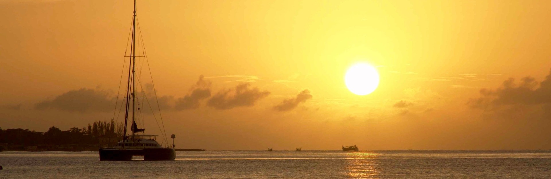 St Martin yacht charter: a catamaran at anchor at sunset