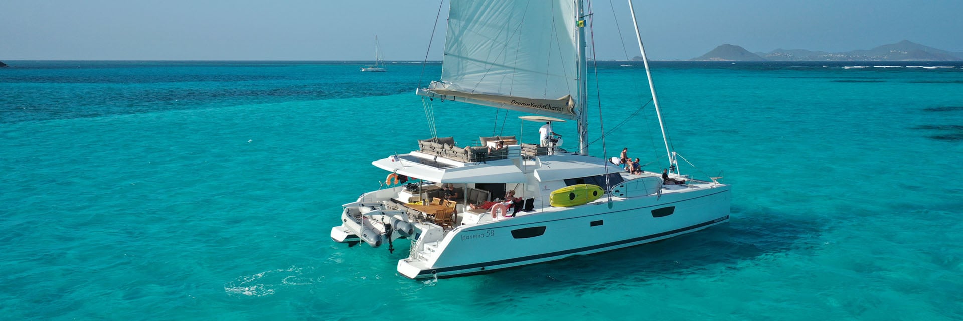 Yacht charter Martinique: a sailing catamaran in turquoise Caribbean water