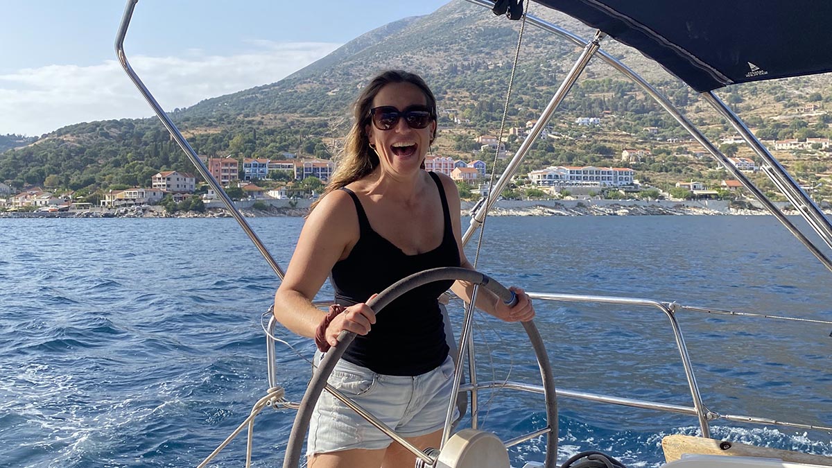 Girl helming sailing yacht in Greek Islands