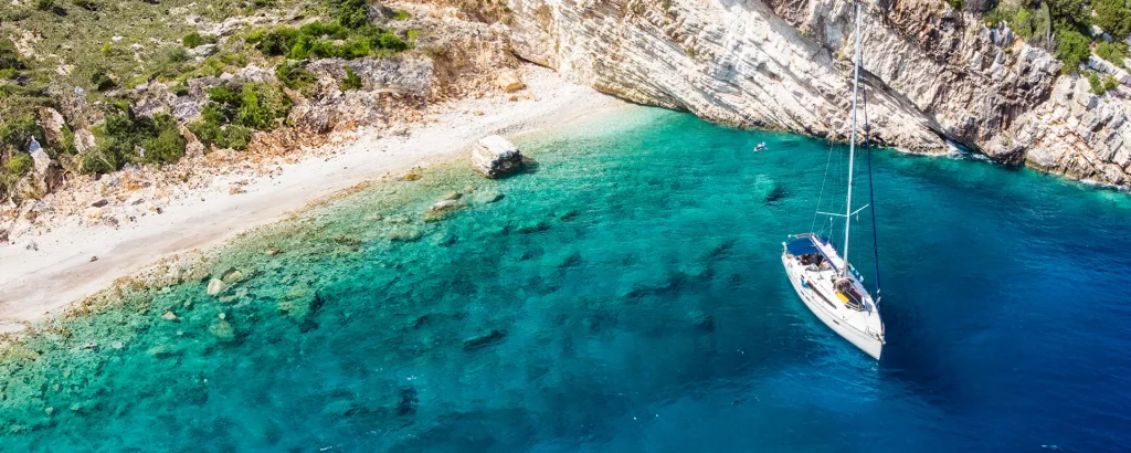 Yacht anchored in a turquoise bay on Ithaca