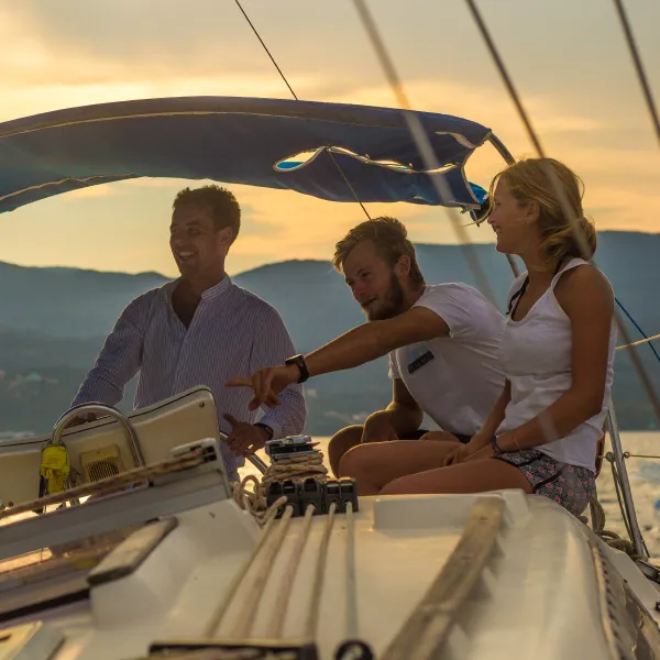 A skipper pointing out the route to guests at the helm on a skippered sailing holiday