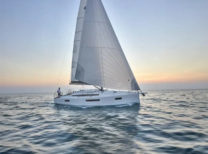 A Sun Odyssey 410 sailing at sunset