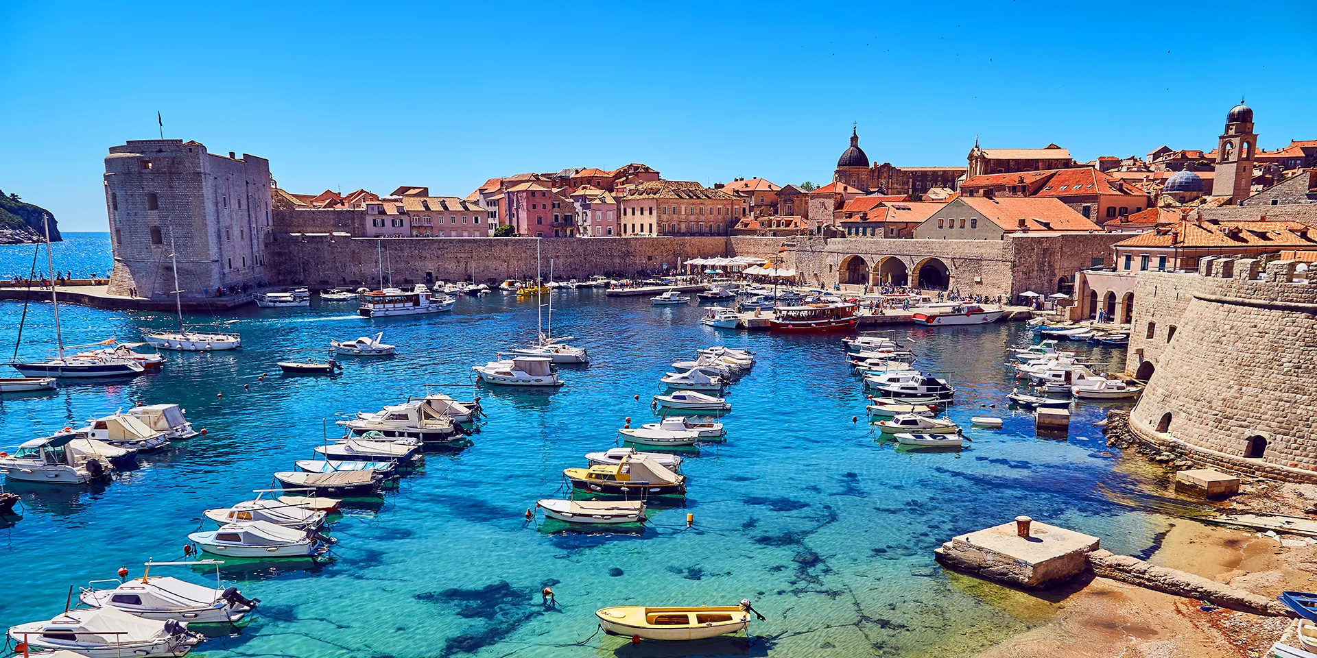 Dubrovnik yacht charter: boats in the old town harbour below the walls of Dubrovnik