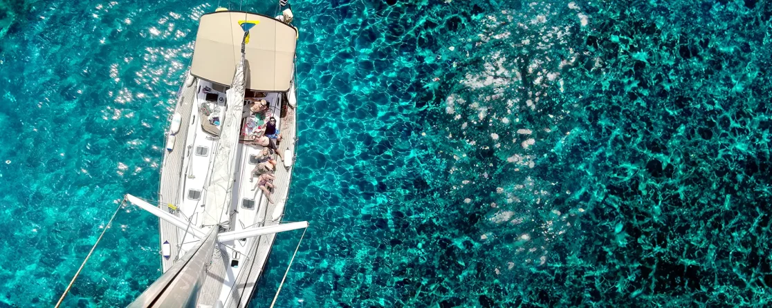 Looking down from the mast of an AHOY yacht sailing in clear blue water