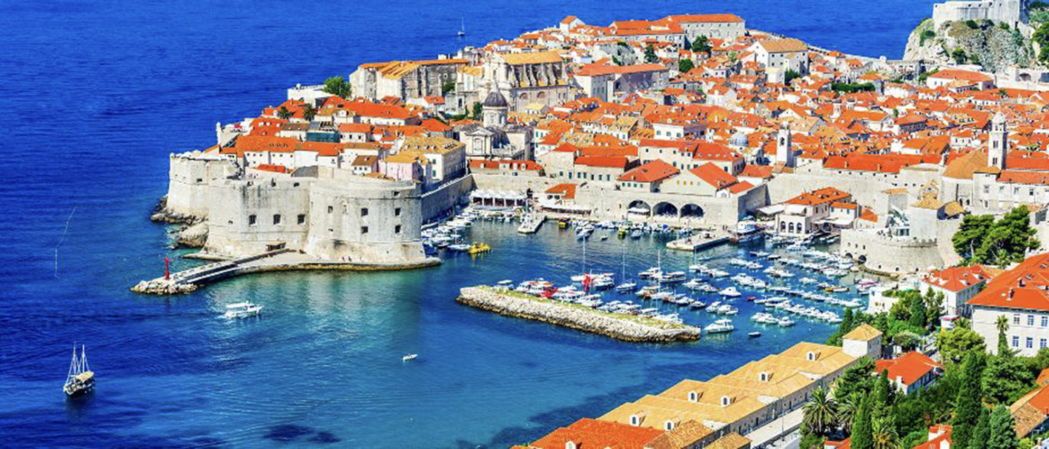 A stunning view of Croatia’s Dalmatian coastline with turquoise Adriatic waters and historic orange-roofed towns