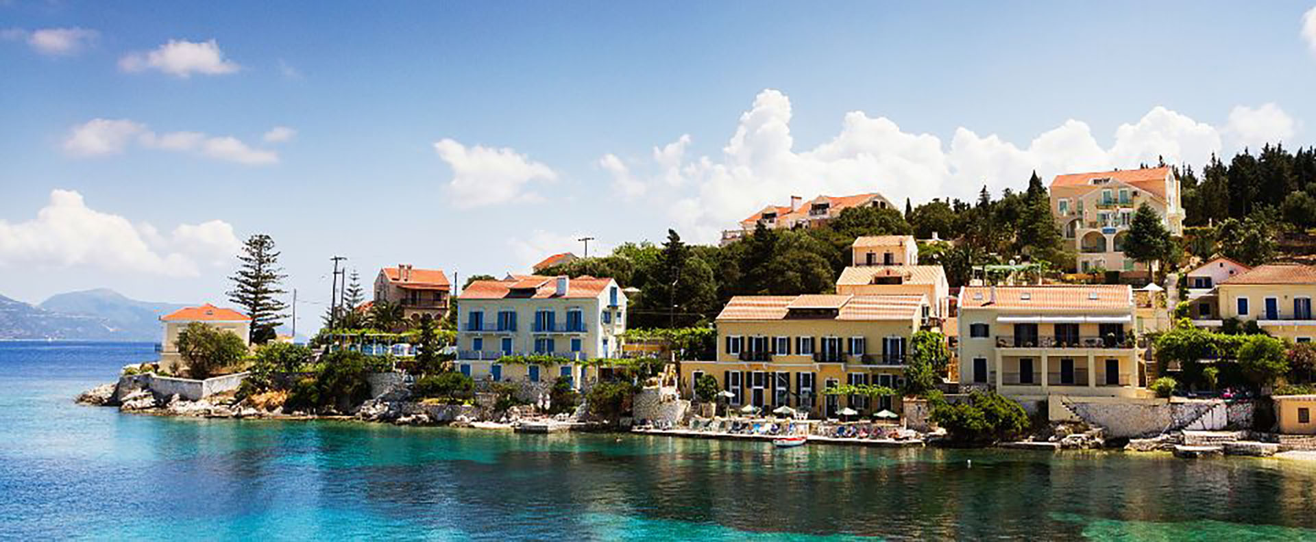 Charming waterfront houses in Fiskardho, Kefalonia, a must-visit destination for Greek island sailing holidays.