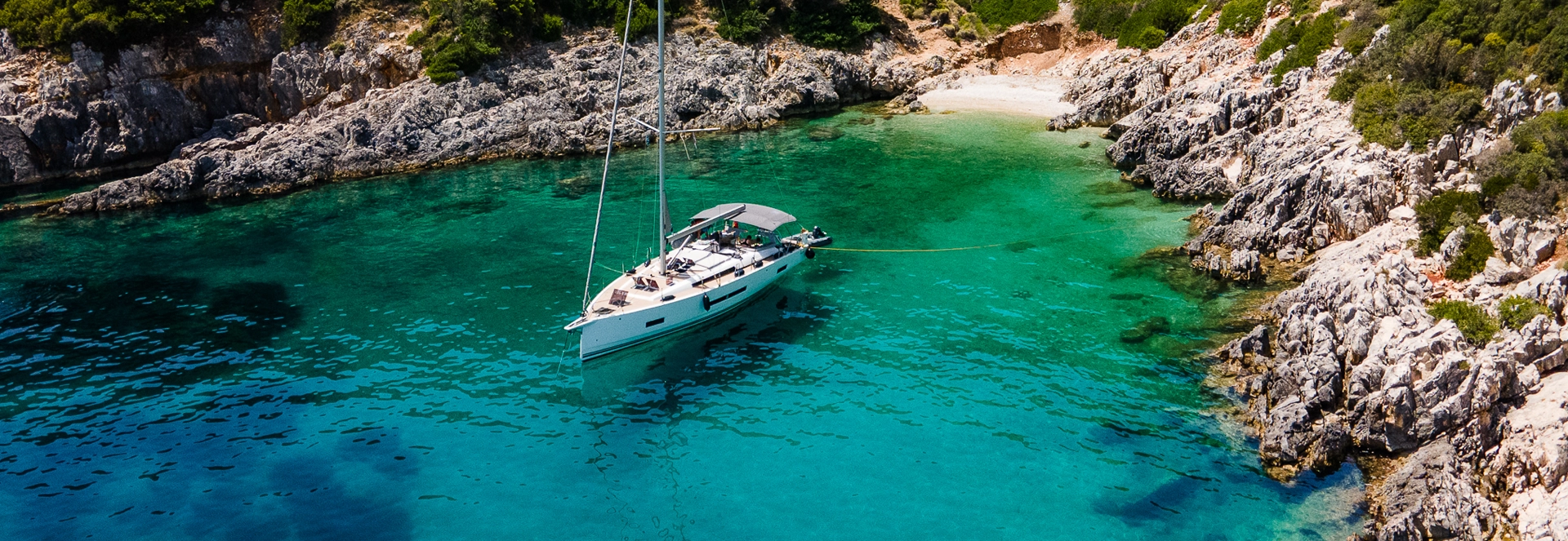 Kefalonia yacht charter: a yacht at anchor in a turquoise cove