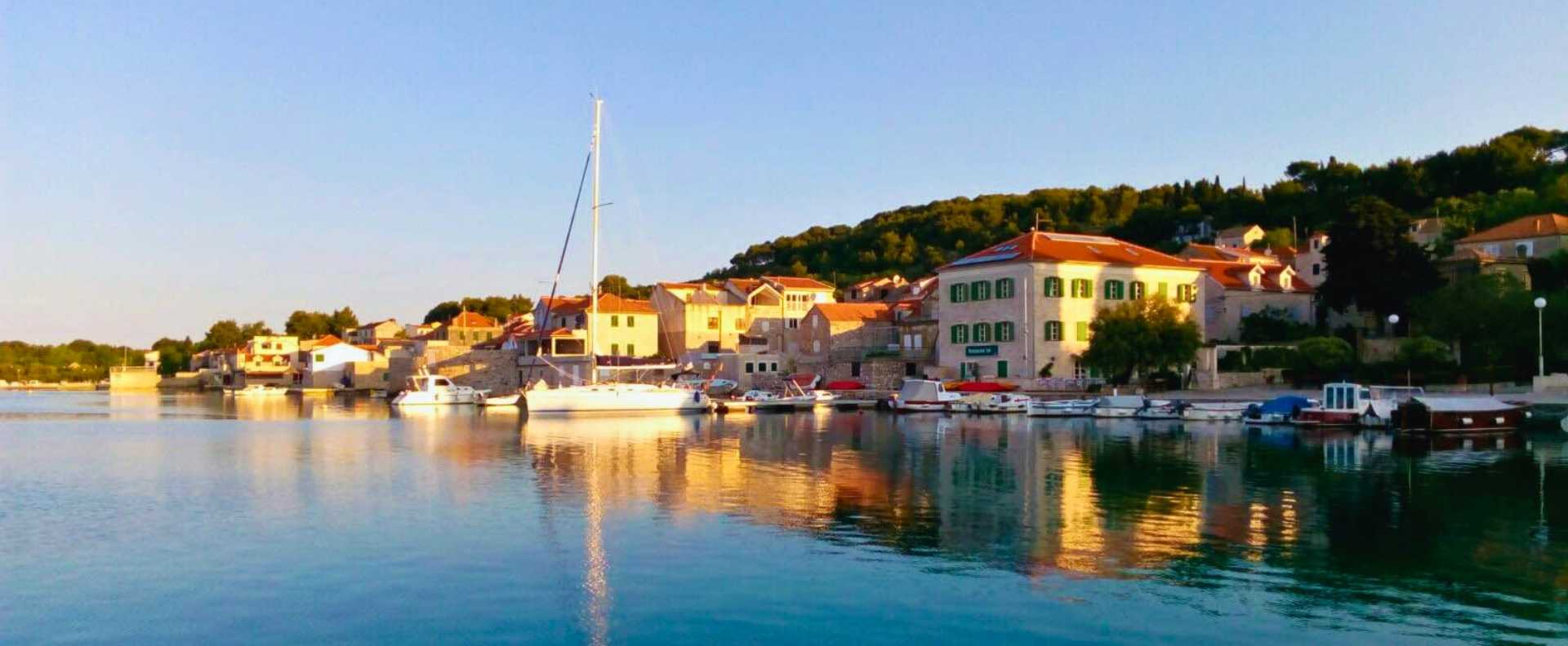 A peaceful Croatian harbour at sunset, where sailors learn to sail on an RYA course