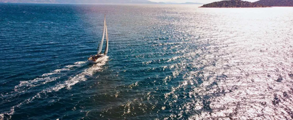 A yacht sails across the open sea, offering hands-on experience in an RYA sailing course