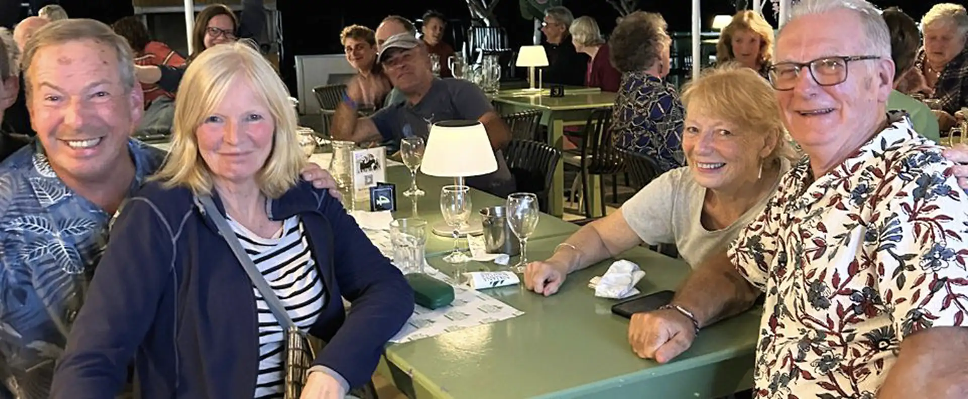 A group of happy Seafarer guests enjoying dinner together after a sailing trip.