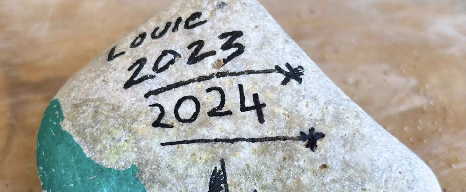 A rock with handwritten 2023 and 2024, marking a Seafarer travel memory