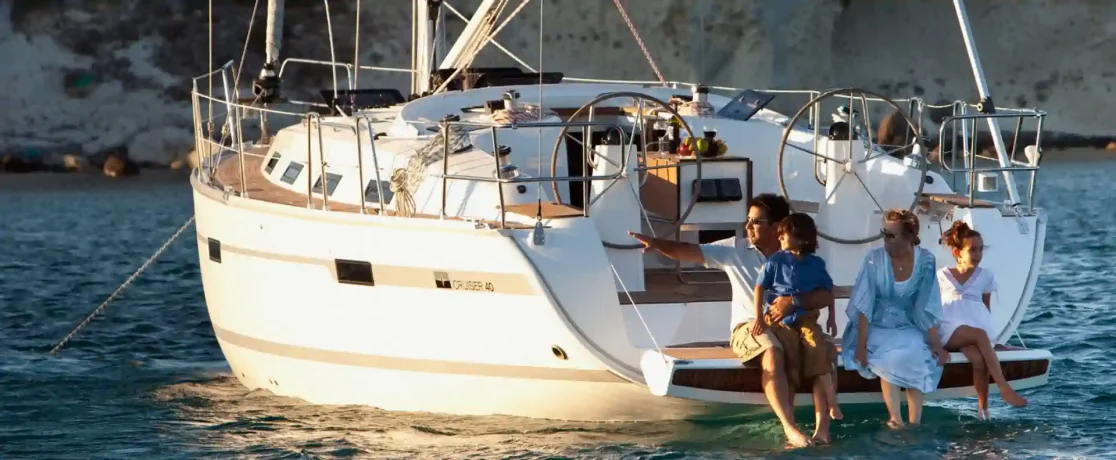 A parent and child relaxing at the stern of a sailing yacht