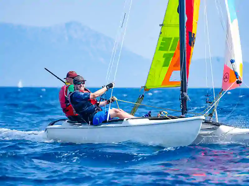 Two sailors enjoying Hobie 15 catamaran sailing off Nikiana Beach Club in Greece – Seafarer Sailing holidays