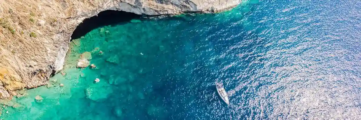 Sailing yacht anchored by Papanikolis Cave in the Ionian Sea during Lefkas Flotilla Sailing Holidays – Seafarer Sailing