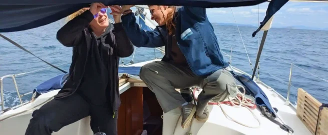 Students working together to trim a sail during an RYA course