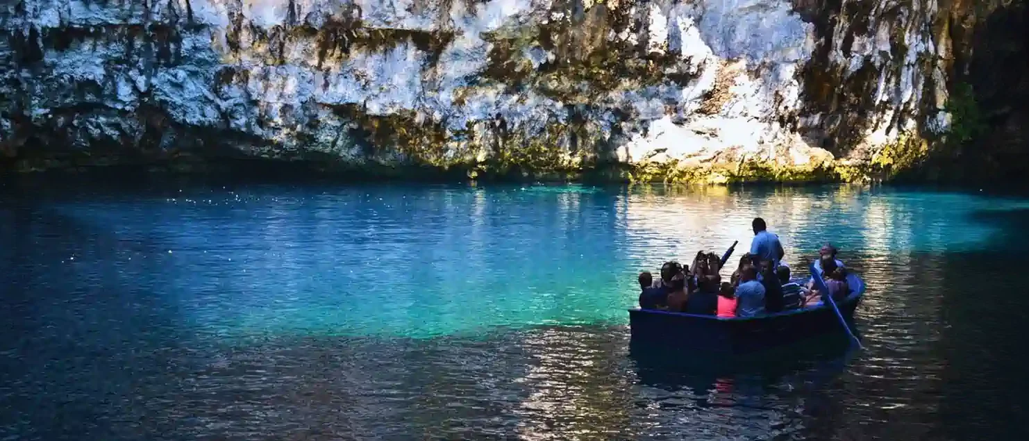 Small group on a boat tour inside a turquoise cave lake in the Ionian Islands