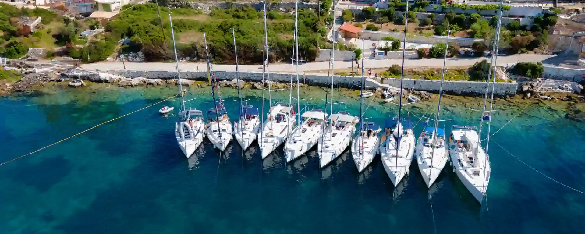 Flotilla of sailing yachts moored side by side in Fiskardo, Kefalonia