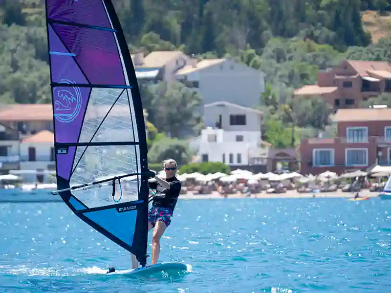 Windsurfer riding on clear waters off Nikiana Beach Club in Greece – Seafarer Sailing holidays
