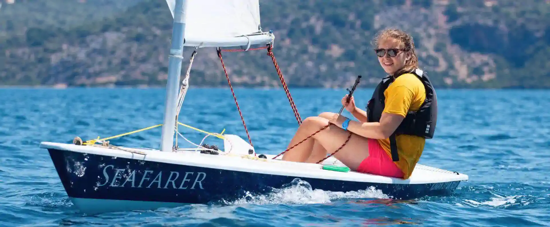 Female sailor practicing dinghy sailing in Greece during RYA Dinghy Instructor course
