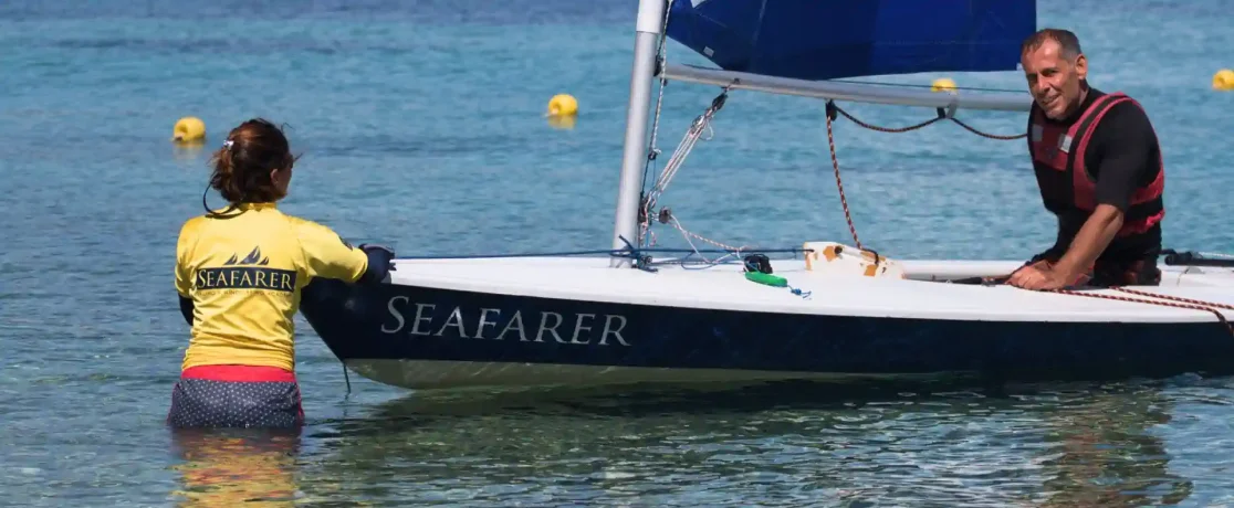 An instructor and a young sailor getting a dinghy ready at Nikiana Beach Club