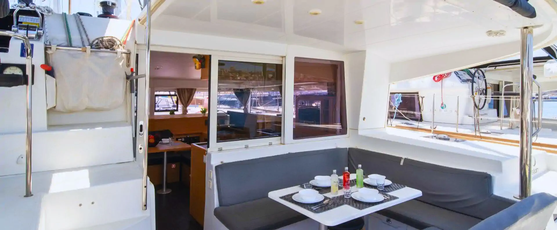 Outdoor cockpit and dining area on the Lagoon 400 sailing catamaran, set for lunch in the marina.