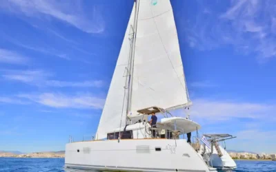 Lagoon 400 sailing catamaran cruising under full sail on calm blue waters off the Greek coast.
