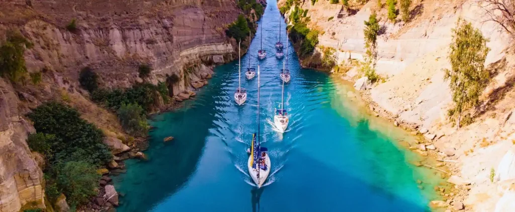 Sailing yachts transiting the Corinth Canal as part of a flotilla sailing route in Greece.