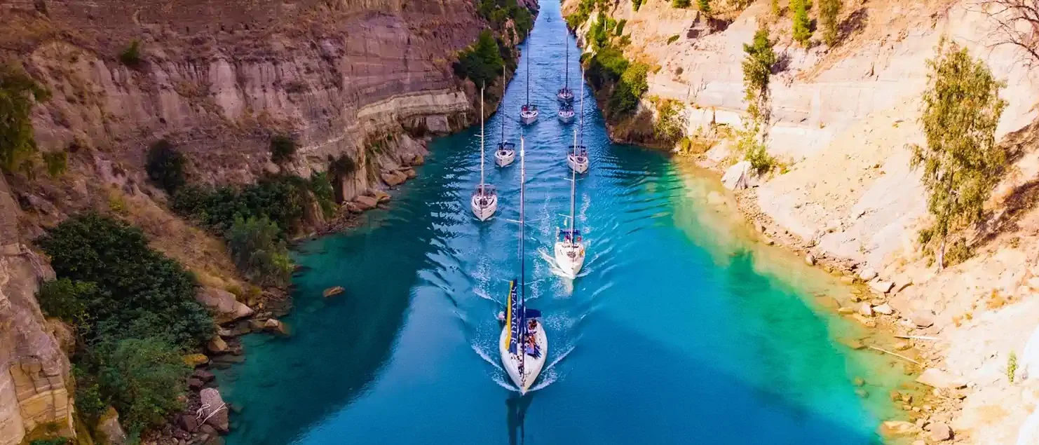 Sailing yachts transiting the Corinth Canal as part of a flotilla sailing route in Greece.