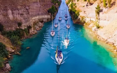 Sailing yachts transiting the Corinth Canal as part of a flotilla sailing route in Greece.