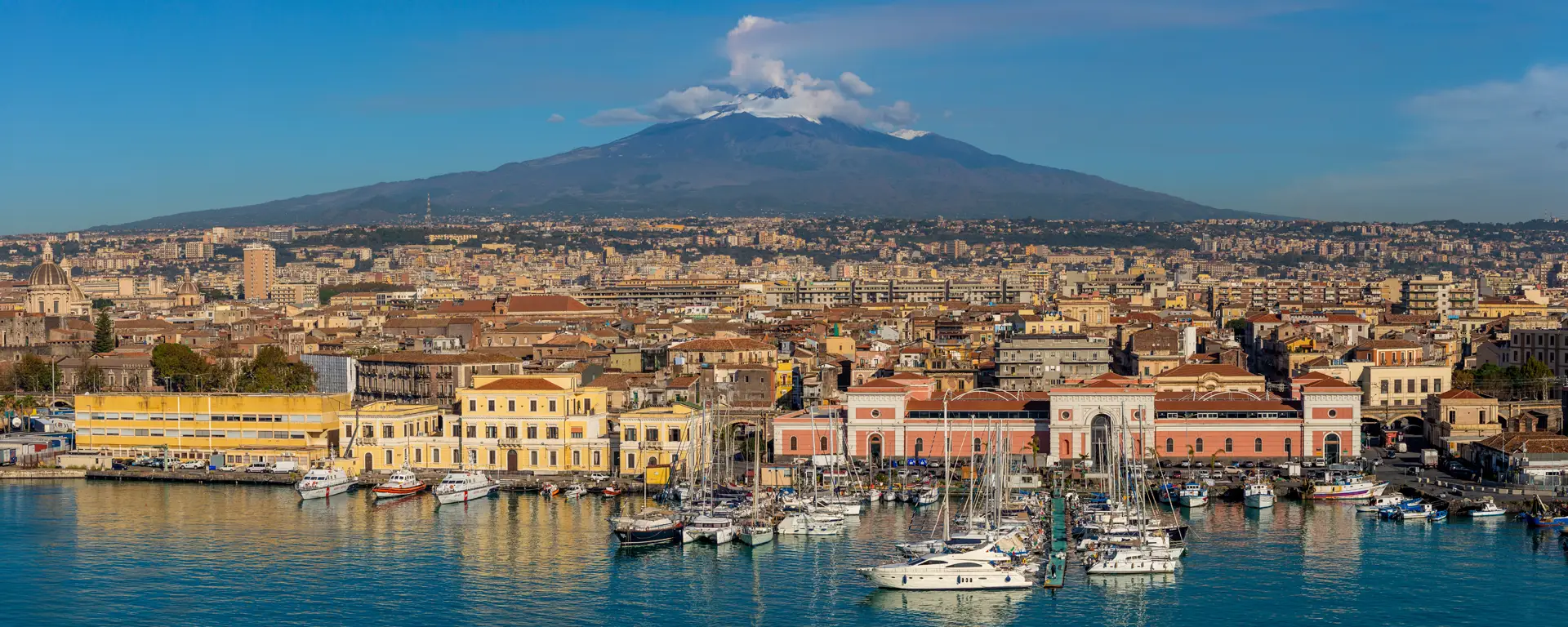 Mount Etna rising above a Sicilian harbour