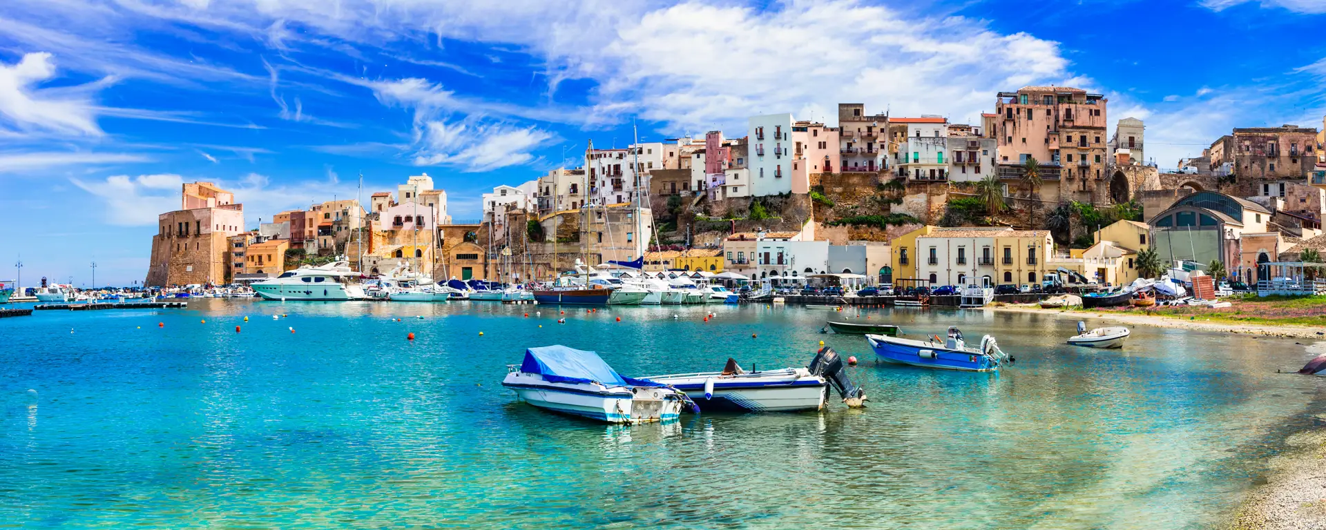 Colourful houses and fishing boats in a Sicilian harbour