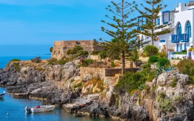 Greek island coastline with whitewashed buildings and moored boats, Greece sailing holiday