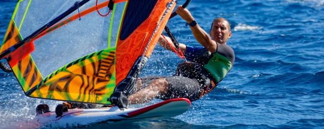 A windsurfer planing across Kefalos Bay