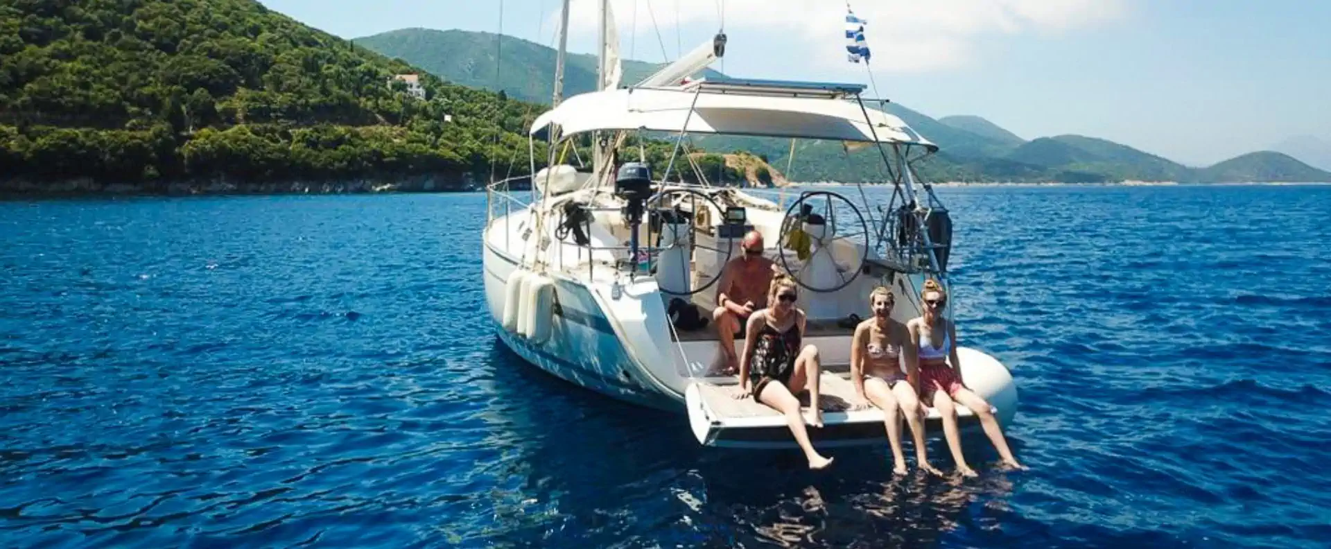 Guests relaxing on a sailing yacht’s swim platform during a Greek sailing holiday