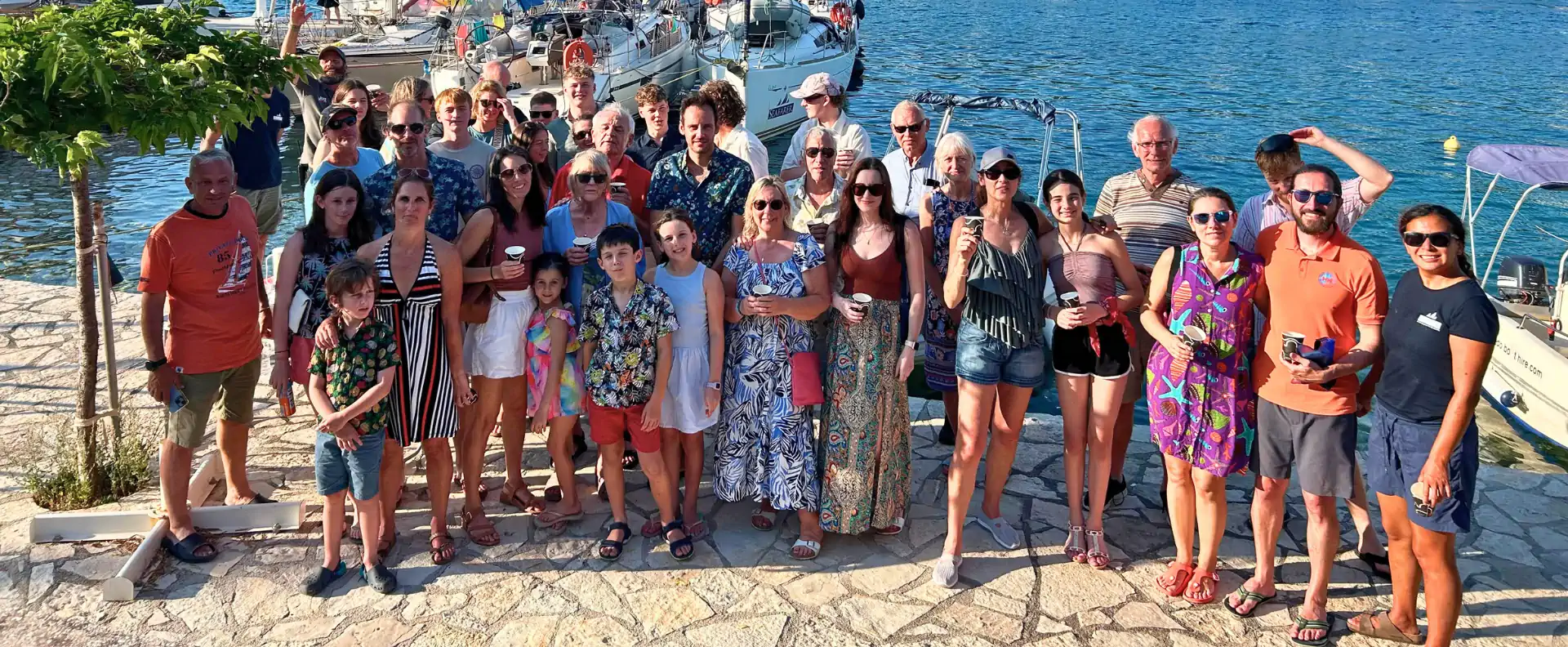 Seafarer flotilla guests gathered together beside their yachts during a Kefalonia sailing holiday