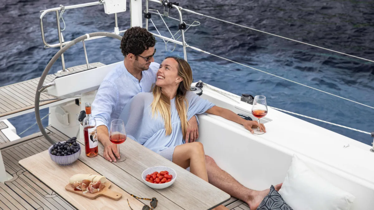 Guests relaxing at the cockpit table of a Bavaria C45
