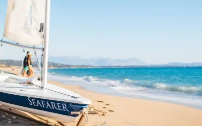 Poseidon beach club holidays Seafarer dinghy Seafarer sailing dinghy on the sand beside turquoise water, ready for beach club holidays at Poseidon